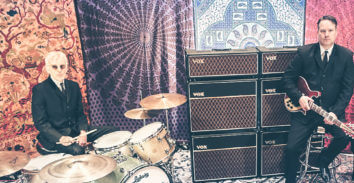 drummer and electric guitar player in front of VOX amplifiers