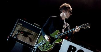 artist, Jay Mehler, playing electric guitar in front of VOX amplifier