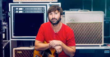 man with guitar in front of VOX amplifiers