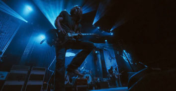 male musician playing electric guitar in concert