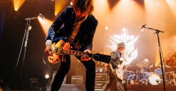 male musician playing electric guitar in concert