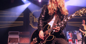 male musician playing electric guitar in concert