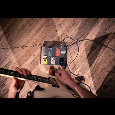 partial view of man playing electric guitar and footboard