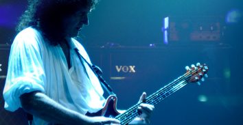 Brian May playing electric guitar in concert