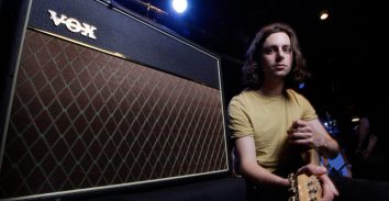 artist, Felix White, holding electric guitar sitting beside VOX amplifier