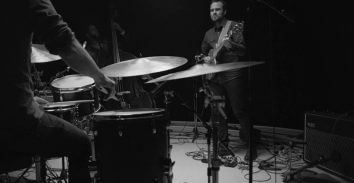 partial veiw of drummer and electric guitar player