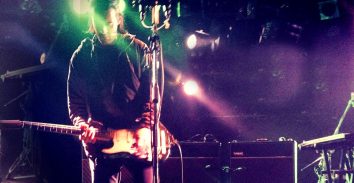 artist, Simon Taylor Davis playing electric guitar in concert