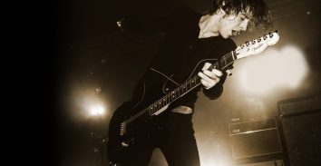 black and white pictire of artist, Van McCann, in concert playing electric guitar