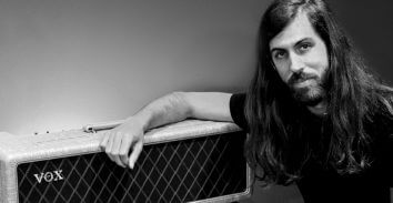 artist, Wayne Sermon, leaning on VOX amplifier