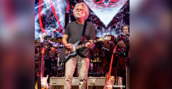male musician playing electric guitar in concert